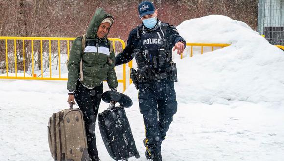 Policía canadiense guía a una mujer en Roxham Road antes del cierre. (GETTY IMAGES).