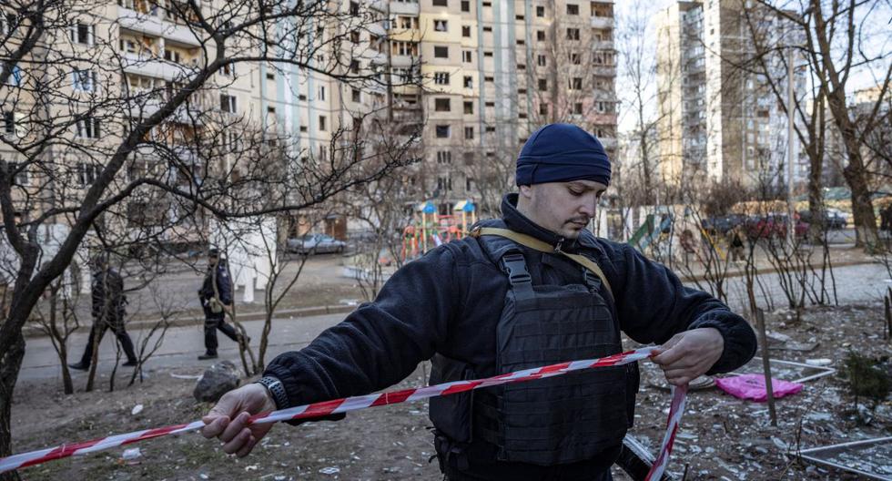 Un oficial de policía ucraniano acordona un área cerca de un edificio residencial que fue alcanzado por los escombros de un cohete derribado en Kiev, Ucrania, el 20 de marzo de 2022. (FADEL SENNA / AFP).