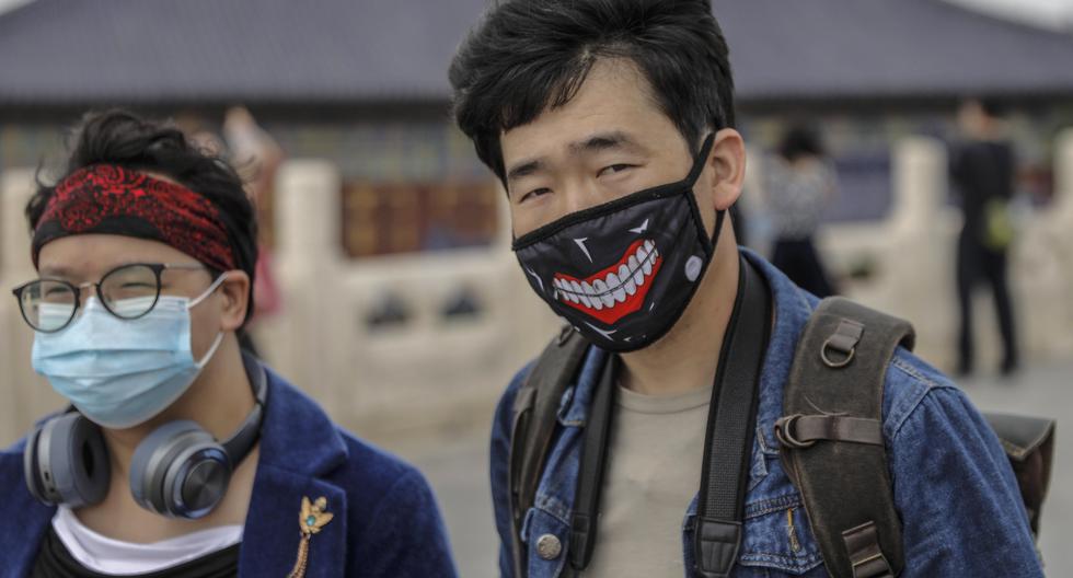 Personas con máscaras protectoras visitan el Templo del Cielo en Beijing, China, país que ha ido relajando las medidas de confinamiento que fueron adoptadas por el coronavirus. (EFE / EPA / WU HONG).
