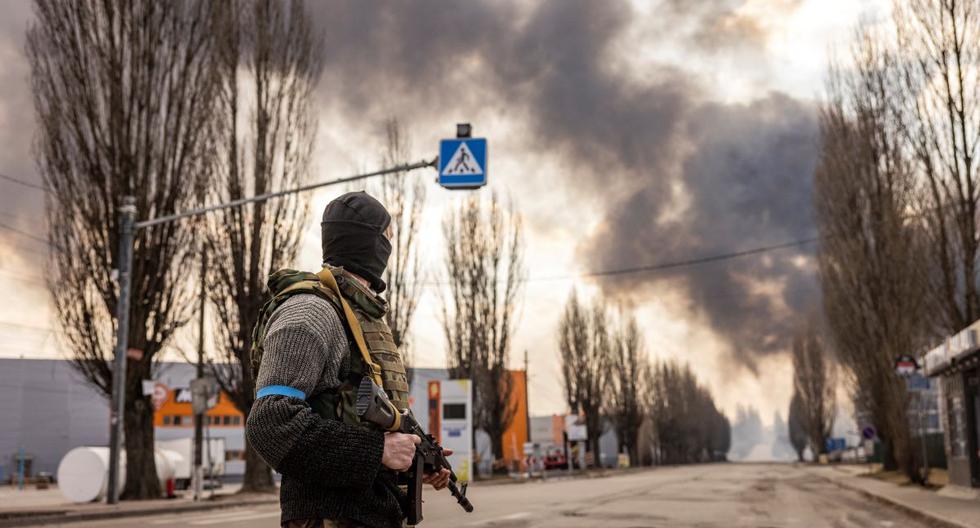 Un militar de Ucrania hace guardia cerca de un almacén en llamas alcanzado por un proyectil ruso en los suburbios de Kiev el 24 de marzo de 2022. (FADEL SENNA / AFP).