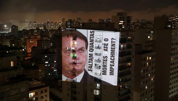 Una imagen del presidente de Brasil, Jair Bolsonaro, con la frase "Cuántas muertes hasta el juicio político", se proyecta en un edificio durante una protesta por sus políticas contra el coronavirus. (REUTERS / Amanda Perobelli).