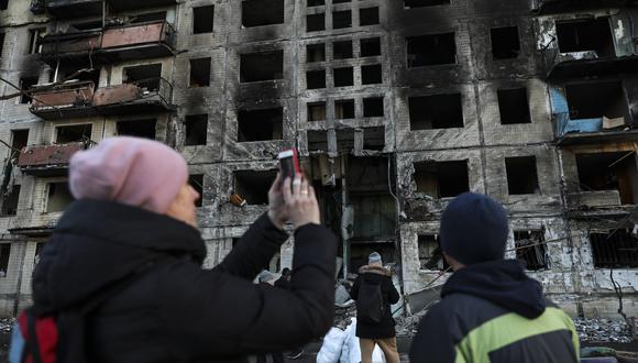 Una mujer tomando fotografías a un edificio dañado tras un bombardeo ruso en Kiev. (EFE/EPA/MIGUEL A. LOPES)