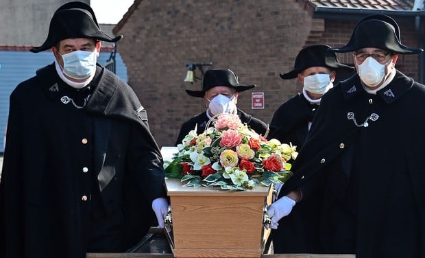 Los miembros de la Hermandad Caritativa de Saint-Eloi de Bethune participan en el funeral de una persona muerta por coronavirus en Francia. (AFP / DENIS CHARLET).