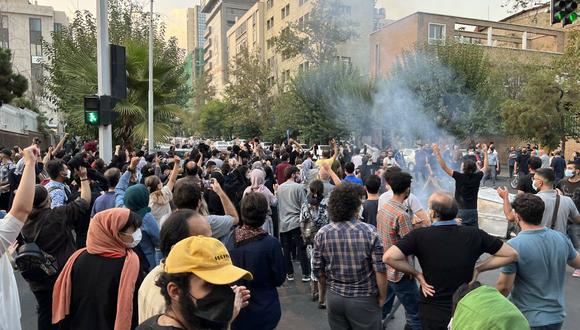 Policía iraní levantando una porra para dispersar a los manifestantes durante una protesta por Mahsa Amini, una mujer que murió después de ser arrestada por la "policía de la moralidad" de la república islámica, en Teherán el 19 de septiembre. 2022. (Foto de AFP)