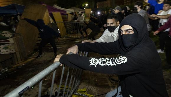 Los contramanifestantes atacan un campamento pro palestino establecido en el campus de la Universidad de California en Los Ángeles (UCLA), el 1 de mayo de 2024. (Foto de ETIENNE LAURENT / AFP).