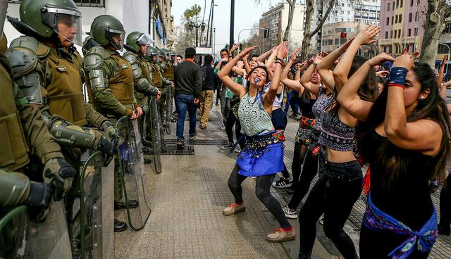 Demonstrators perform a dance in front of riot policemen during a march called by students to request changes in the education system in Santiago, Chile September 5, 2017. REUTERS/Ivan Alvarado     TPX IMAGES OF THE DAY
