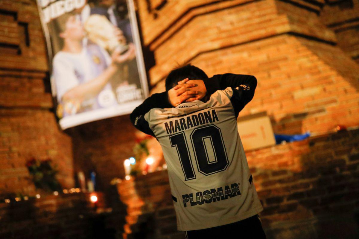 Un fan hace un gesto mientras rinde homenaje a la leyenda del fútbol argentino Diego Armando Maradona el día después de su muerte, en Barcelona.  (REUTERS/Nacho Doce).