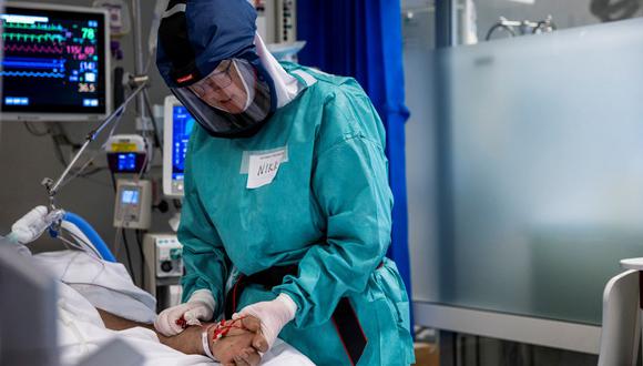 Una fotografía tomada el 27 de noviembre de 2020 muestra a Anniken Hars tratando a un paciente de coronavirus en la unidad de cuidados intensivos del Hospital Universitario de Oslo, en Noruega. (Jil Yngland / NTB / AFP).