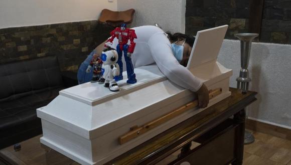 Julieres Acevedo abraza el ataúd de su hijo Joshue de 4 años el día después de su muerte durante su velatorio en Caracas, Venezuela, el miércoles 27 de octubre de 2021. Joshue, que tenía leucemia, murió mientras esperaba un trasplante de médula ósea. (AP /Ariana Cubillos)