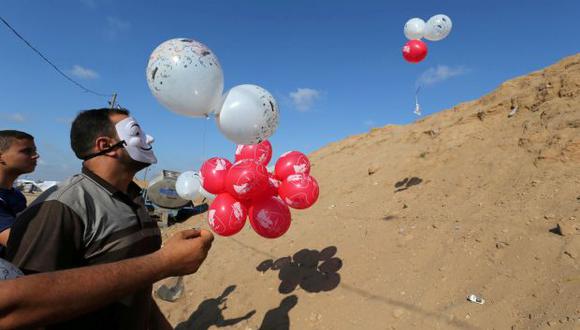 Los palestinos llevan globos cargados con material inflamable para ser arrojados al lado israelí, cerca de la frontera entre Israel y Gaza en el centro de la Franja de Gaza. (Foto: Reuters)