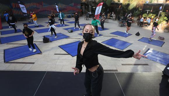 Jóvenes participan en una clase de baile al aire libre en el Centro Cultural Gabriela Mistral (GAM), el 22 de julio de 2021 en Santiago (CHILE). Los cines desempolvan sus butacas, los museos amplían su catálogo de actividades y los actores vuelven a los escenarios en la mayor parte de Chile, donde la pandemia remite y la cultura trata de resurgir tras más de un año contra las cuerdas por las duras restricciones. EFE/Elvis González