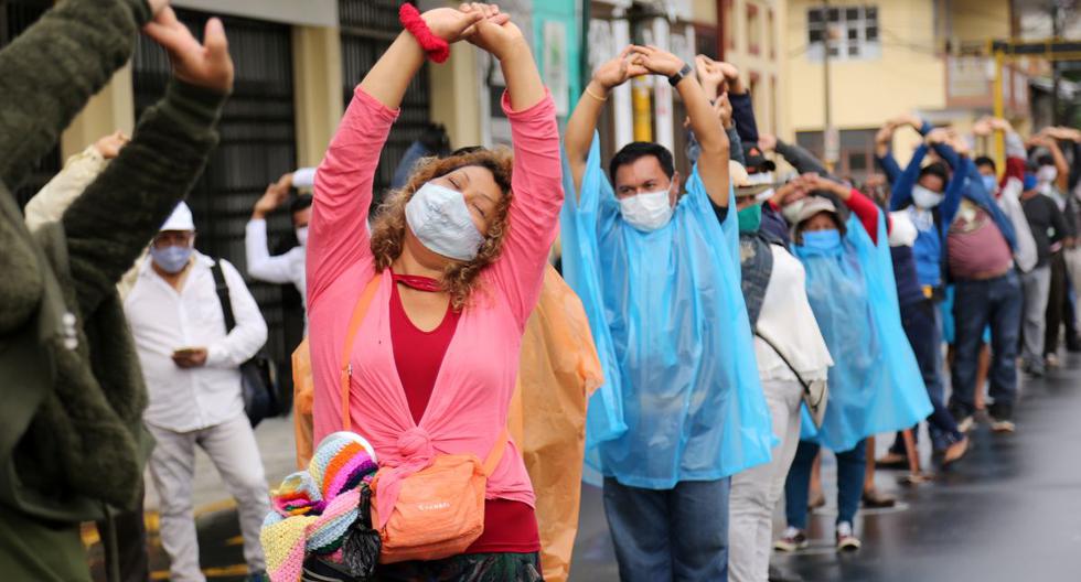 Ciudadanos peruanos hacen ejercicios guiados por militares mientras hacen la cola para entrar a un banco. Perú, así como Brasil, México y Chile son algunos de los países más golpeados por el coronavirus. (Foto: Cesar Von BANCELS / AFP)