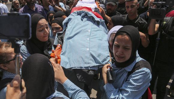 Las niñas de la escuela palestina lloran durante el funeral de su compañero de clase Sadil Naghnaghiya, de 15 años, en Jenin, en la Cisjordania ocupada, el 21 de junio de 2023. (Foto por AFP)