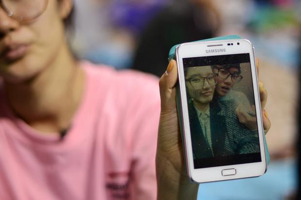 Hana Kim, de 22 años, muestra una fotografía de su hermano Kim Dong Hyup, de 16 años, desaparecido tras el hundimiento del ferry Sewol. (Foto de ED JONES / AFP).