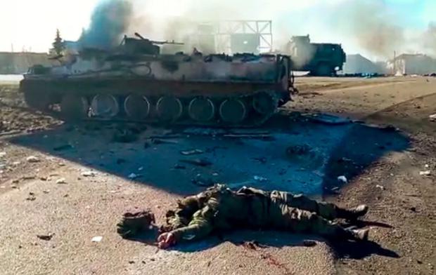 Image taken from a video released by the Press Service of the Ukrainian Police Department, the body of a dead soldier lies on the ground next to wrecked military vehicles after an attack allegedly carried out by separatists or Russians in eastern Ukraine, on Thursday February 24, 2022. Russian troops have launched their anticipated attack on Ukraine.  Huge explosions were heard before dawn in Kyiv, Kharkiv and Odessa as world leaders condemned the start of a Russian invasion that could cause massive casualties and topple Ukraine's democratically elected government.  (Ukrainian Police Department Press Service via AP)