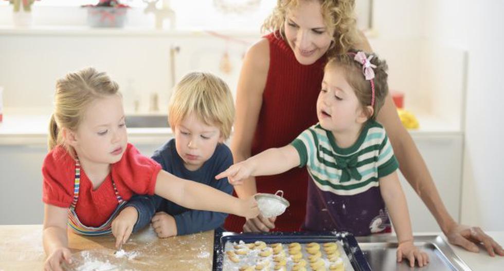 Madre preparando galletas con sus tres hijos