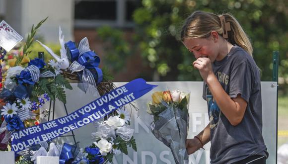 Una niña llora mientras lleva flores a un memorial para las víctimas tras el tiroteo masivo en la Escuela Primaria Robb en Uvalde, Texas, EE.UU.