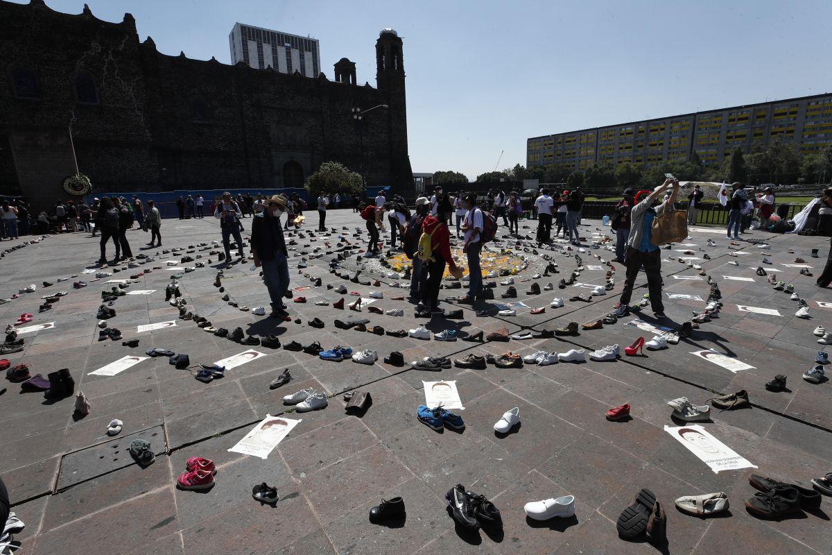 Un grupo de personas colocan ofrendas en la explanada de la Plaza de las Tres Culturas para conmemorar el aniversario de la masacre de estudiantes, en Tlatelolco, Ciudad de México. (EFE/José Méndez).