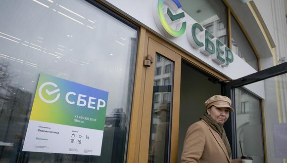 Una mujer sale de una sucursal de la compañía de servicios bancarios Sberbank, de propiedad mayoritariamente estatal de Rusia, recientemente sancionado por Suiza. (Foto: Natalia KOLESNIKOVA / AFP)