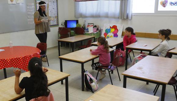 Niños israelíes asisten a una clase en la Escuela Primaria Sadot mientras el país alivia las restricciones por la pandemia de coronavirus COVID-19. (Foto de JACK GUEZ / AFP).