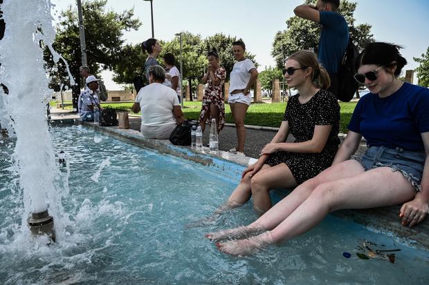 Tourists cool off at a fountain in Thessaloniki on July 14, 2023, as Greece suffers a heat wave.  (Photo: AFP)