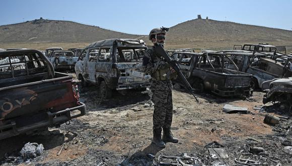 Un miembro de la unidad militar talibán Badri 313 se encuentra junto a los vehículos dañados en la base destruida de la CIA en el distrito de Deh Sabz al noreste de Kabul el 6 de septiembre de 2021. (AAMIR QURESHI / AFP).