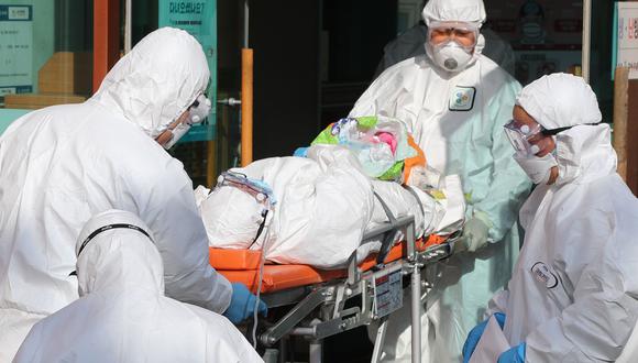 Perú es uno los casi 100 países que suman cerca de 100.000 contagios de coronavirus en el mundo. En la imagen, médicos trasladan a un paciente en Corea del Sur. Foto: AFP