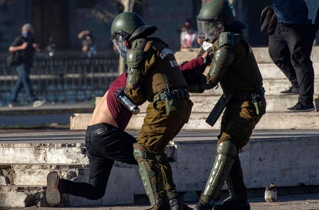 Un manifestante es arrestado por la policía antidisturbios durante los enfrentamientos posteriores a una protesta contra el gobierno del presidente chileno Sebastián Piñera en Santiago. (AFP/MARTIN BERNETTI).