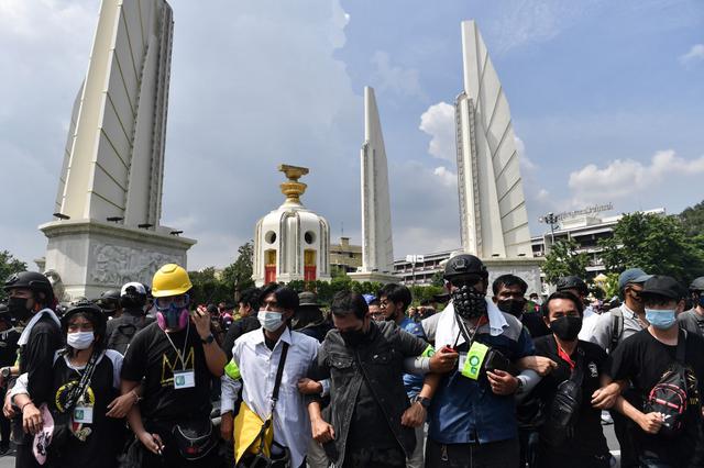 Los manifestantes a favor de la democracia forman una línea alrededor del Monumento a la Democracia durante una manifestación contra el gobierno en Bangkok. (Lillian SUWANRUMPHA / AFP)