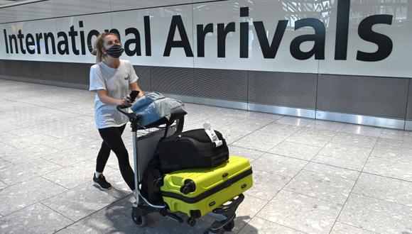 En esta foto de archivo tomada el 10 de julio de 2020, una pasajera que usa mascarilla debido a la pandemia de coronavirus llega al aeropuerto de Heathrow, al oeste de Londres, Reino Unido. (Foto de DANIEL LEAL-OLIVAS / AFP).