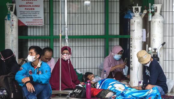 La gente espera la admisión afuera de la sala de emergencias de un hospital que atiende a pacientes de coronavirus Covid-19 en Surabaya, Indonesia, el 11 de julio de 2021. (Foto de Juni Kriswanto / AFP).