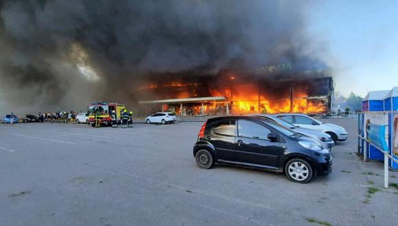 Los bomberos apagando el fuego en un centro comercial afectado por un ataque con misiles rusos en la ciudad de Kremenchuk, en el este de Ucrania. (AFP).