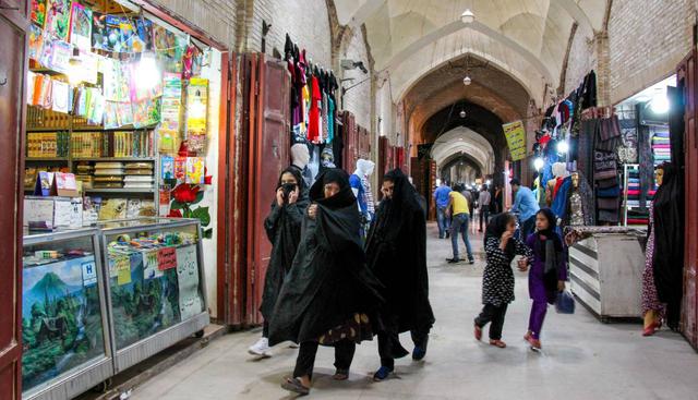 La agencia Isna difundió fotos de personas con máscaras comprando en una tienda de electrónica en Mashhad. (ISNA / AFP).