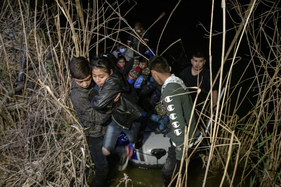 Un grupo de inmigrantes de Honduras y Guatemala, que llegan ilegalmente desde México, desembarcan de un bote inflable en el lado estadounidense del río Bravo, antes de solicitar asilo, entregándose a agentes de la patrulla fronteriza en la ciudad fronteriza de Roma, Texas. (Foto: Ed Jones / AFP)