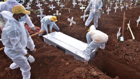 Trabajadores funerarios entierran a un hombre que murió de coronavirus Covid-19 en un cementerio en Bekasi, Indonesia, el 6 de agosto de 2021. (Rezas / AFP).