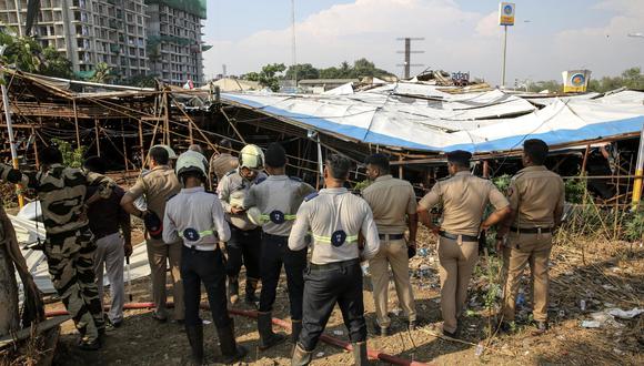 Agentes de policía indios inspeccionan los daños mientras miembros de la Fuerza Nacional de Respuesta a Desastres (NDRF) y otros rescatistas limpian los escombros durante una operación de rescate en el lugar donde un cartel gigante se derrumbó sobre una gasolinera bomba, en Mumbai, India, 14 de mayo de 2024. EFE/EPA/DIVYAKANT SOLANKI