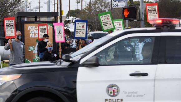 Un vehículo de LAPD pasa mientras la gente protesta por los asesinatos de personas a manos de la policía, incluida la muerte de George Floyd y Daunte Wright el 12 de abril de 2021. (Foto de Patrick T. FALLON / AFP)