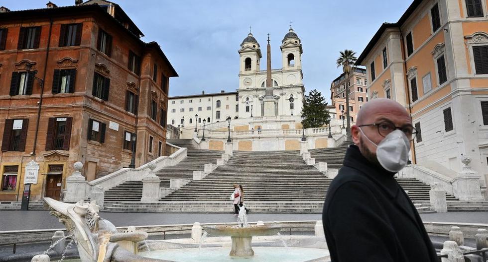 Un hombre con una máscara de protección camina por una desierta Piazza di Spagna en el centro de Roma. (AFP)