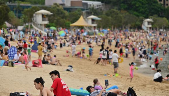 Imagen de archivo de personas que toman el sol y se bañan en la playa Repulse Bay de Hong Kong, el 3 de abril de 2021. (PETER PARKS / AFP).