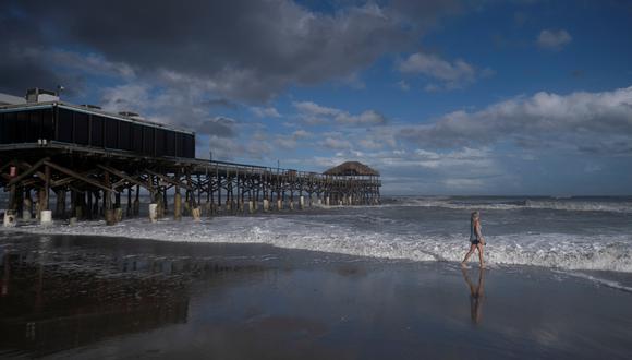 Una mujer camina por la playa junto al muelle de Westgate Cocoa Beach tras el paso del huracán Nicole en Cocoa Beach, Florida, EE.UU. (Foto referencial)