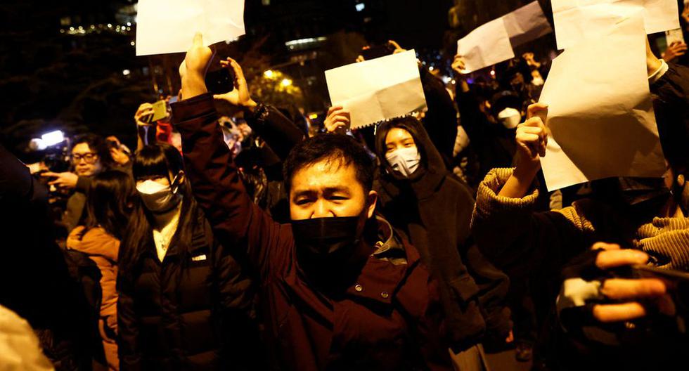 Las personas se reúnen para una vigilia y sostienen hojas de papel blancas en protesta por las restricciones por coronavirus (COVID-19) en Beijing, China , 27 de noviembre de 2022. (REUTERS/Thomas Peter).