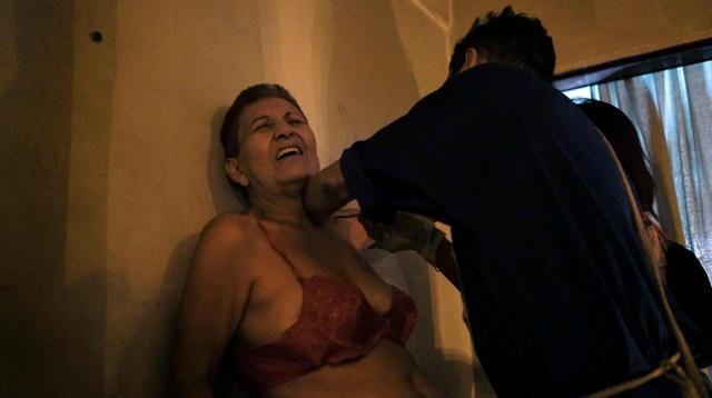 La venezolana Rosa Sáez, de 77 años, es tratada por el curandero espiritual "Hermano Guayanese" en el barrio de Petare, Caracas. (AFP / Matias Delacroix).