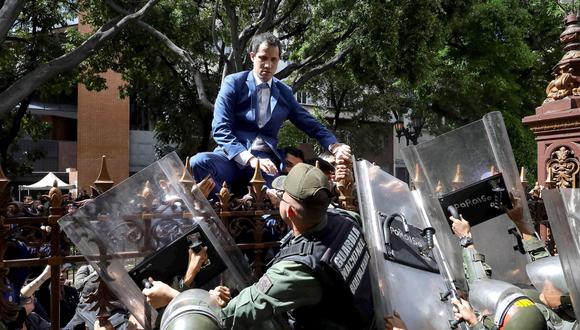 El momento en el que Juan Guaidó intentó entrar a la Asamblea Nacional de Venezuela trepando una reja. (EFE/ Rayner Peña).