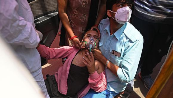 Un paciente respira con la ayuda de oxígeno al costado de la carretera en medio de la pandemia de coronavirus Covid-19 en Ghaziabad, India, el 26 de abril de 2021. (Foto de Sajjad HUSSAIN / AFP).