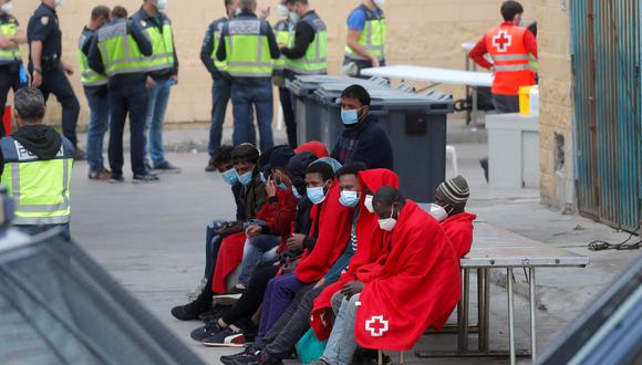 Migrantes siendo vigilados por la policía española en Ceuta. REUTERS