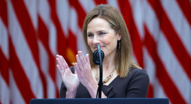 La jueza Amy Coney Barrett hace un gesto mientras el presidente de los Estados Unidos, Donald Trump, realiza un evento para anunciarla como su nominada para ocupar el asiento de la Corte Suprema que quedó vacante tras la muerte de la jueza Ruth Bader Ginsburg. (REUTERS/Carlos Barria).