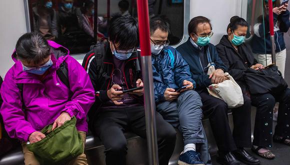 Personas con máscaras viajan en tren el primer día del Año Nuevo Lunar de la Rata en Hong Kong, como medida preventiva después de un brote de coronavirus de Wuhan. (Foto: AFP)