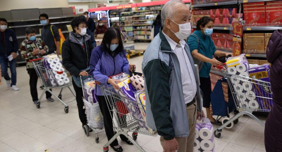 Los ciudadanos chinos usan máscaras faciales y se abastecen de rollos de papel higiénico en un supermercado en Hong Kong. (Foto: EFE).