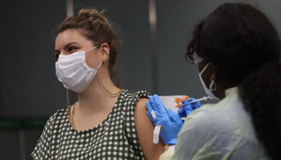 Una joven recibe una vacuna Pfizer-BioNtech COVID-19 de un trabajador de la salud en el Aeropuerto Internacional de Miami, Florida. (Foto: Archivo / Joe Raedle / Getty Images / AFP).