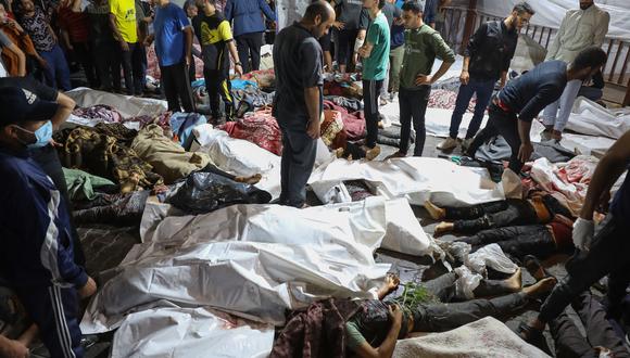 Personas reunidas alrededor de los cuerpos de palestinos muertos en un bombardeo de Israel contra el hospital árabe Ahli en el centro de Gaza. (Foto de Dawood NEMER / AFP).